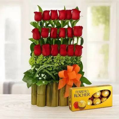 Arreglo Floral Musca - Rosas - Cuando se ama a una persona se hace hasta lo imposible por conquistar su corazón, regala este hermoso arreglo floral y demuestra todo tu afecto, este diseño se ha elaborado en una base bambú o madera con 18 rosas y follajes verdes. El diseño incluye una caja de chocolates Ferrero Rocher por 8 unidades. Sugerimos que acompañes este diseño con chocolates, peluches, globos o vinos para hacer aún más especial tu detalle, en el siguiente paso de la compra puedes agregar a tu orden estos productos si lo deseas. - Floresco
