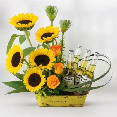 Arreglo con Girasoles Temis - Flores Tropicales - A ellos también les encanta recibir flores... a través de este lindo diseño puedes expresar tus sentimientos hacia ese hombre especial en tu vida, sobre una base de madera se ubican 5 girasoles, rosas, follajes verdes y 4 cervezas. Sugerimos que acompañes este diseño con chocolates, peluches o vinos para hacer aún más especial tu detalle, en el siguiente paso de la compra puedes agregar a tu orden estos productos si lo deseas. - Floresco