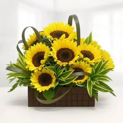 Arreglo con Girasoles Soleil - Flores Tropicales - Envía este lindo diseño floral a ese ser especial y llena de felicidad y armonia su día, se encuentra elaborado sobre un base de madera y se compone de 12 girasoles y follajes verdes. Sugerimos que acompañes este diseño con chocolates, peluches o vinos para hacer aún más especial tu detalle, en el siguiente paso de la compra puedes agregar a tu orden estos productos si lo deseas. - Floresco