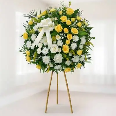 Corona Fúnebre Estamos Contigo - Fúnebres - La mejor forma de acompañar y rodear a la familia de la persona fallecida es enviando un arreglo floral, puedes expresar tu sentido pésame de la mejor manera enviando esta elegante corona fúnebre sobre un trípode de bambú, la cual se encuentra elaborada con rosas amarillas, fuyi o crisantemos blancos y follajes verdes. - Floresco