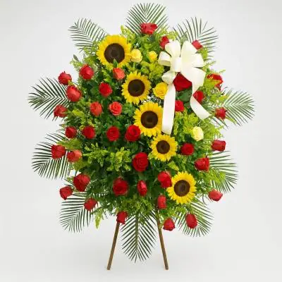 Pedestal Fúnebre Solemne - Fúnebres - En momentos difíciles como la pérdida de un ser querido siempre queremos manifestar nuestras condolencias, este hermoso pedestal compuesto de rosas rojas, girasoles y follajes verdes es ideal para enviar a la funeraria o al lugar en el cual se están realizando las honras fúnebres. - Floresco