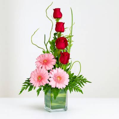 Solitario Tu Recuerdo - Solitarios - Este sencillo y delicado diseño floral tipo solitario se encuentra elaborado sobre una base de vidrio, se compone de 4 rosas rojas, 3 gerberas y follajes verdes. Es un arreglo ideal para cualquier ocasión. Sugerimos que acompañes este diseño con chocolates, peluches o vinos para hacer aún más especial tu detalle, en el siguiente paso de la compra puedes agregar a tu orden estos productos si lo deseas. - Floresco