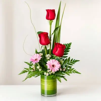 Solitario Pienso en Ti - Jarrones - Este sencillo y delicado diseño floral tipo solitario se encuentra elaborado sobre una base de vidrio, se compone de 3 rosas rojas, 2 gerberas y follajes verdes. Es un arreglo ideal para cualquier ocasión. Sugerimos que acompañes este diseño con chocolates, peluches, globos o vinos para hacer aún más especial tu detalle, en el siguiente paso de la compra puedes agregar a tu orden estos productos si lo deseas. - Floresco